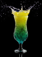 Multicolored smoky swirls in a splahing cocktail glass isolated on black background.