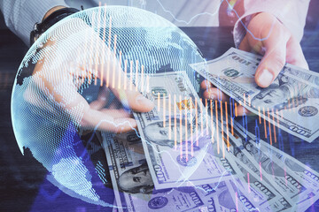 Multi exposure of financial graph drawing hologram and USA dollars bills and man hands. Analysis...