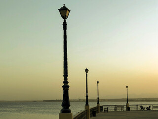 Photo of a sea with street lights and a beautiful sky