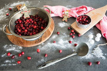 red fresh cranberries in metal colander and vintage spoon