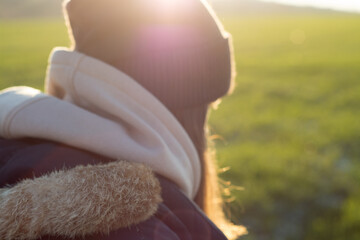 Fototapeta na wymiar Back shot of woman in field with backlight 