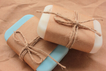 Handmade soap bars on craft wrapping paper background. 