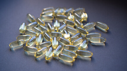Fish oil capsules with omega 3 on dark background. Health care concept. Pile of capsules Omega 3