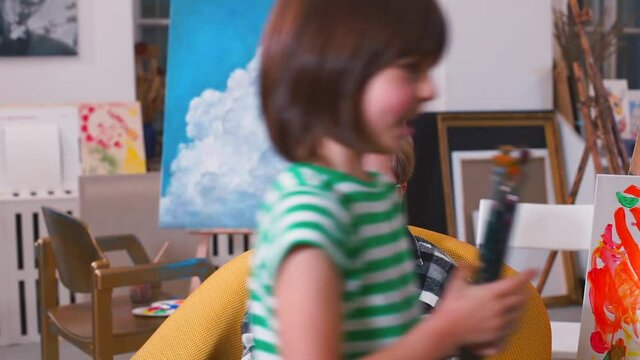 Kids in an inclusive school help each other, a smiling boy in a striped T-shirt takes a set of brushes from a classmate with special needs. Amateur video shakes, first experience in video shooting.