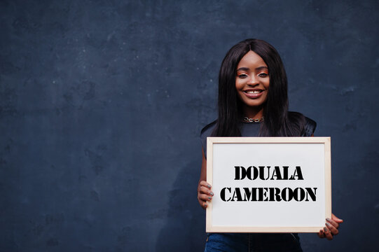 African woman hold white board with Douala Cameroon inscription. Most populous city in Africa concept.