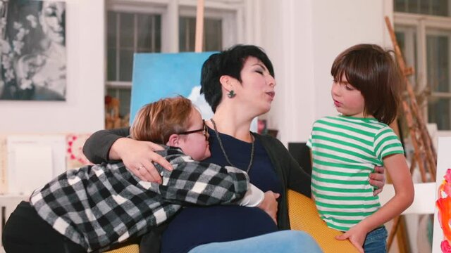 A pregnant woman hugs two boys. Parenting a child with Down syndrome. Mom who are older than 35 are more likely to have a baby affected by the condition.