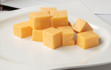 Queso cheddar cortado para aperitivo, vista cenital. Sliced ​​cheddar cheese for appetizer, overhead view.