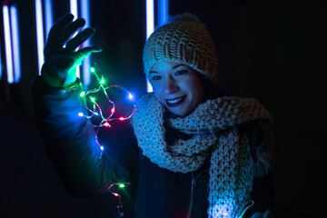 A girl looking at the Christmas lights on the street.