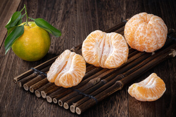 Fresh green tangerine mandarin orange on dark wooden table background.