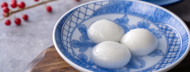 Fototapeta na wymiar Close up of tangyuan in a bowl on gray table, food for Winter Solstice.