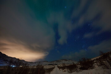 Obraz na płótnie Canvas Aurora borealis Green northern lights above mountains