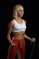 Fit good looking woman doing exercises with elastic band