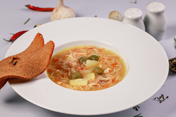 Chicken soup with vegetables, spices, quail eggs and croutons. Food still life. Close-up