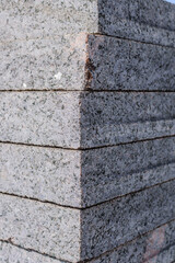 Concrete or granite gray square pavement slabs or stones for floor, wall or path stacked. Industry manufacturing or building concept