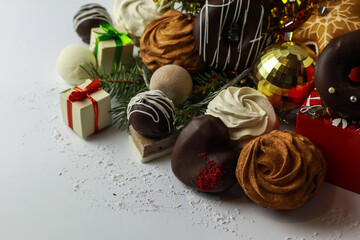 Tasty sweets , zephyr and christmas decorations on light background