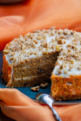 Delicious carrot cake on orange color organza cloth with a spoon