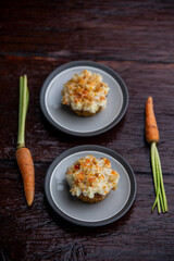 Delicious homemade carrot cupcakes or muffins with ingredients on wooden rustic background