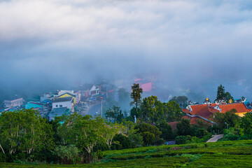 Many houses in in the mist in the morning. Early morning fog and mist burns off over large houses nestled in green rolling hills