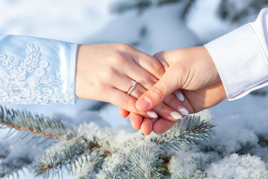 Hands of the bride and groom with rings, winter wedding.