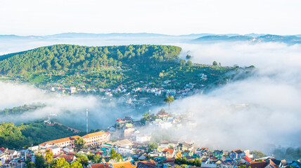 Fototapeta premium Many houses in in the mist in the morning. Early morning fog and mist burns off over large houses nestled in green rolling hills