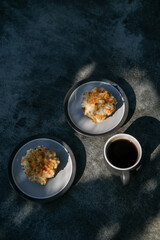 Delicious homemade carrot cupcakes or muffins and cup of coffee on minimalist stone grey background with shadows