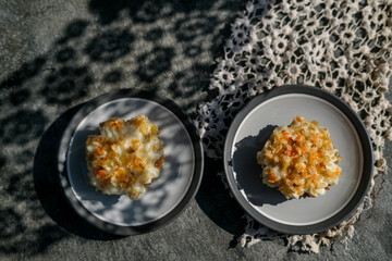 Delicious homemade carrot cupcakes or muffins on minimalist stone grey background with lace shadows