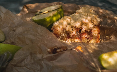 Delicious sliced apple pie with ingredients on parchment baking paper with lace shadows