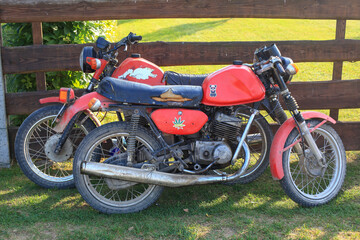 Fototapeta na wymiar Old red soviet motorcycle parked in the park/