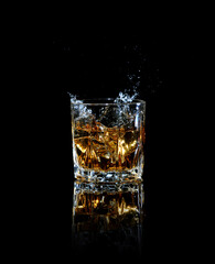 Whiskey splashing out of glass