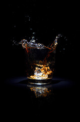 Whiskey with splash on black background