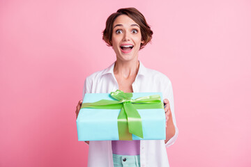 Photo of cheerful impressed young lady wear white shirt getting turquoise gift box isolated pink color background