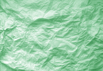 Crumpled green paper sheet surface.