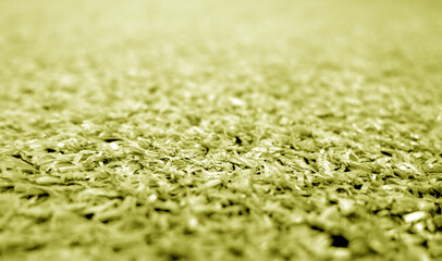 Yellow color artificial grass close-up with blur background