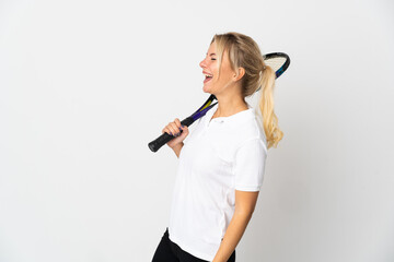 Young Russian woman tennis player isolated on white background laughing in lateral position