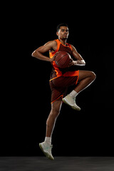 Jumping high. Young purposeful african-amrican basketball player training, practicing in action,...