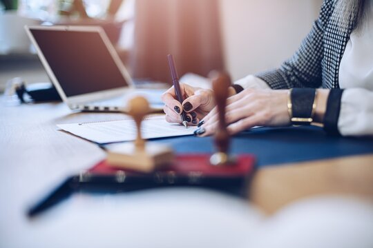 Woman notary public signing and notarizing contract document