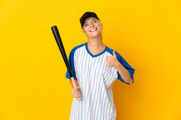 Young Russian woman isolated on yellow background playing baseball and with thumbs up because something good has happened