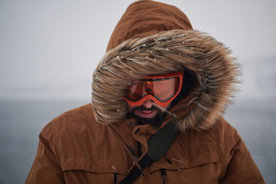 Man At Winter In Stormy Weather Wearing Warm Fur Jacket