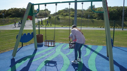 Naklejka premium mother with a child on the Playground
