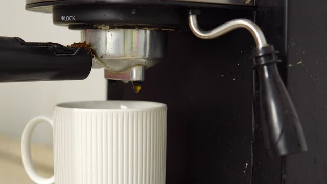 A broken, dirty coffee machine needs to be repaired and is making an espresso. The coffee maker needs renovation. Refurbishment concept.