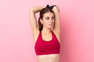 Young sport woman over isolated pink background stretching