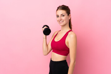 Young sport woman over isolated pink background making weightlifting