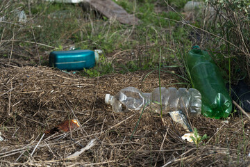 Garbage spilled in a natural setting. Empty dirty plastic bottles. Environmental pollution. Ecological problem.