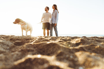 Loving couple with dog outside at the beach