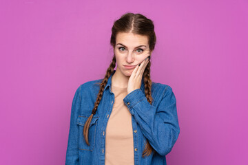 Young woman over isolated purple background unhappy and frustrated