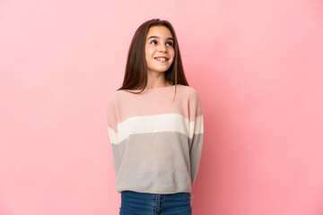 Little girl isolated on pink background thinking an idea while looking up