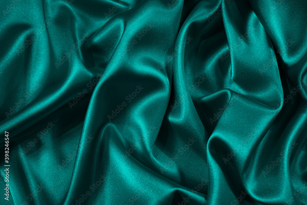Wall mural blue green silk satin fabric. teal color elegant background. liquid wave or silk wavy folds. beautif