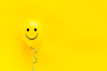 Happiness emotion face on balloon - joy mood background. Top view, copy space - obrazy, fototapety, plakaty