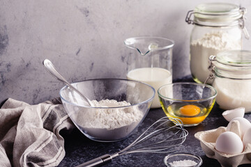 Cooking ingredients for dough, eggs, flour, sugar, milk.