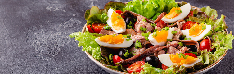 salad Nicoise with tuna, eggs, green beans, tomatoes,  olives, lettuce and anchovies